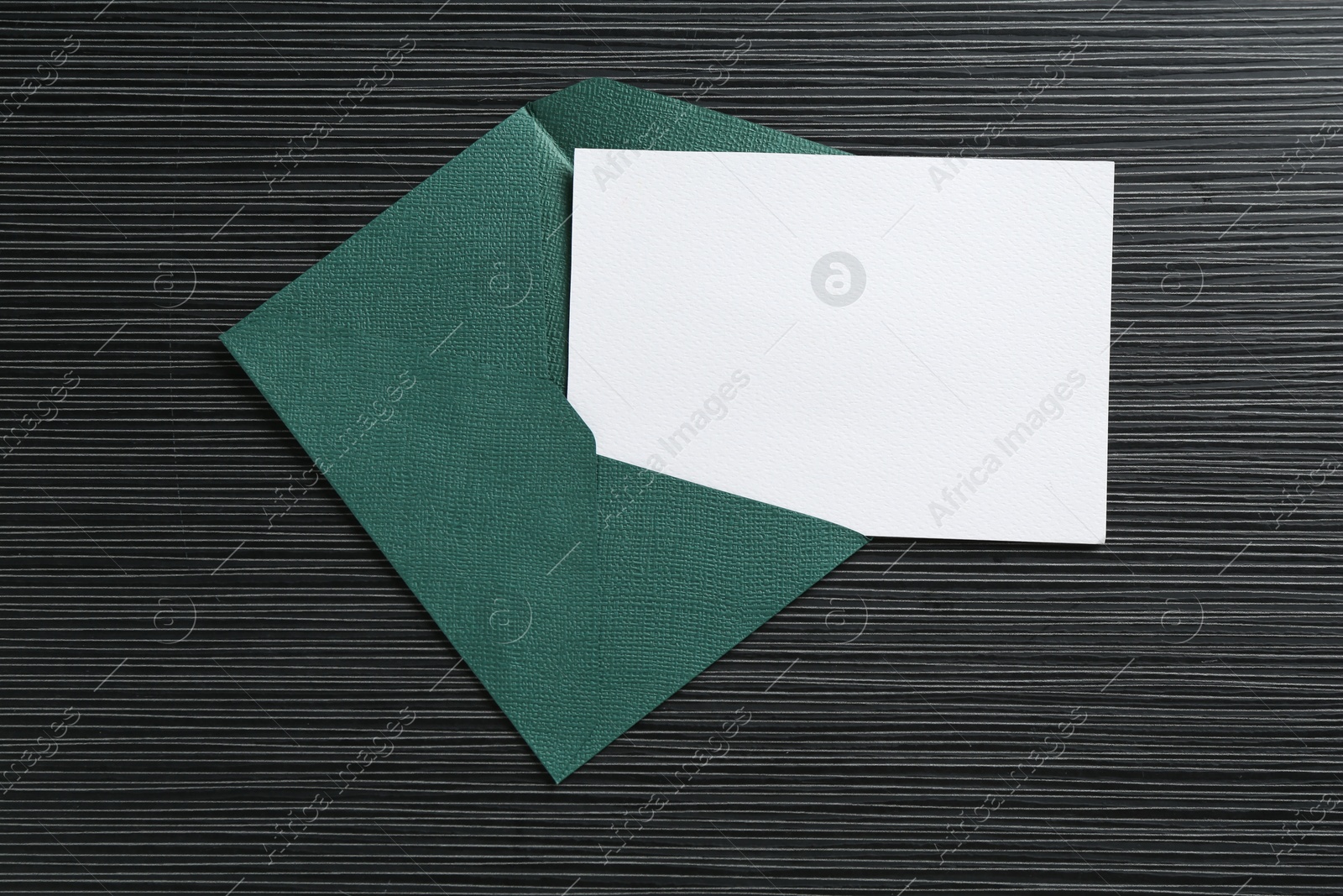Blank invitation card and envelope on black textured table, top view. Space for design Photo of Blank invitation card and envelope on black textured table, top view. Space for design