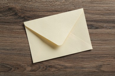 Photo of Beautiful invitation envelope on wooden table, top view