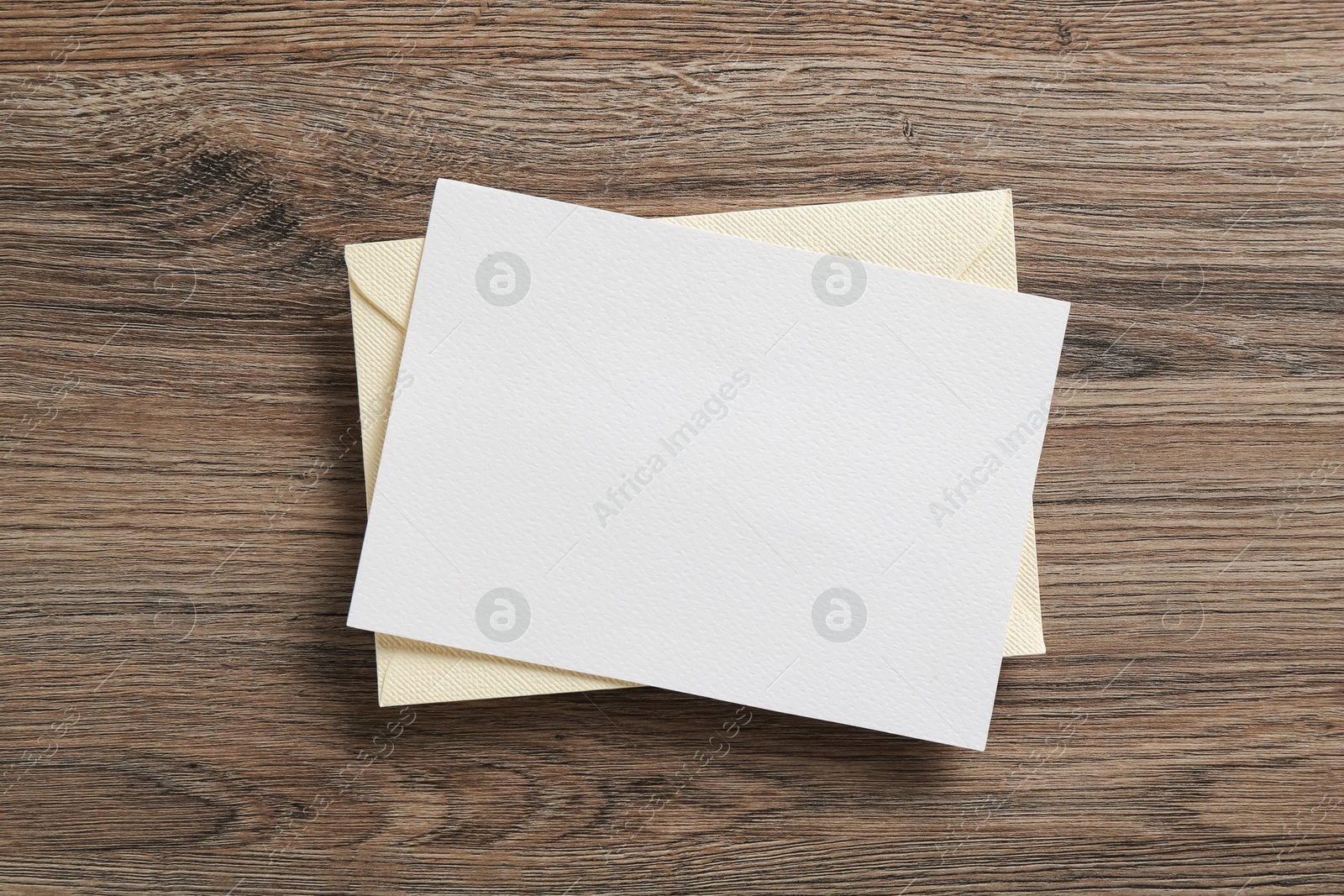 Blank invitation card and envelope on wooden table, top view. Space for design Photo of Blank invitation card and envelope on wooden table, top view. Space for design