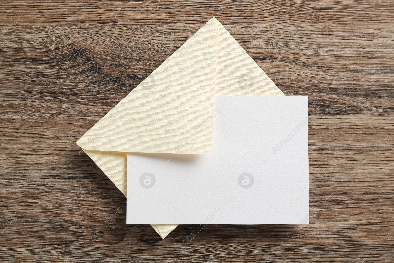 Blank invitation card and envelope on wooden table, top view. Space for design Photo of Blank invitation card and envelope on wooden table, top view. Space for design