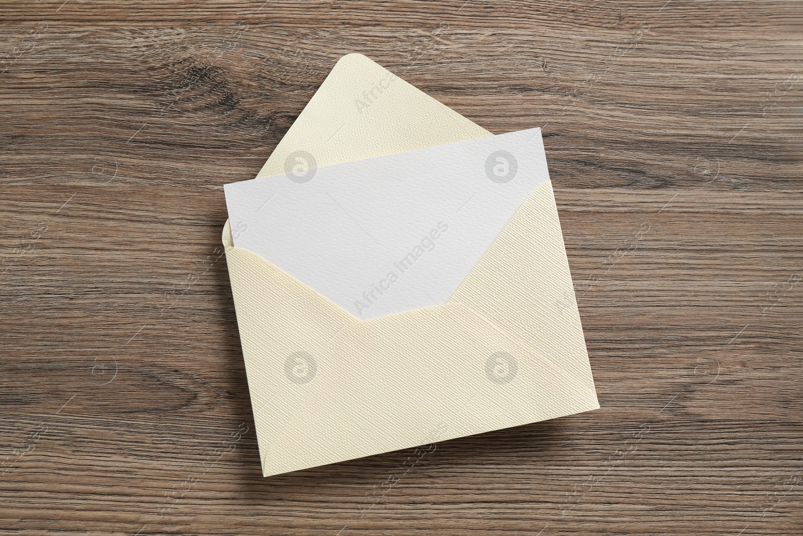 Blank invitation card and envelope on wooden table, top view Photo of Blank invitation card and envelope on wooden table, top view