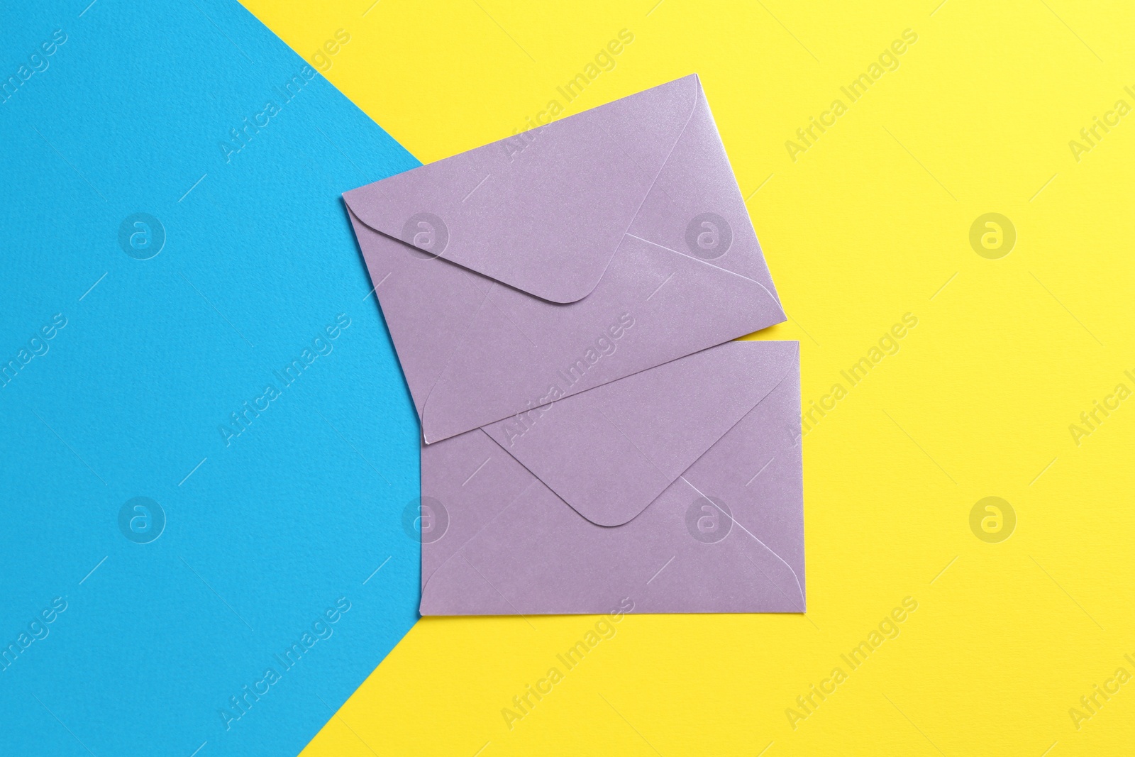 Beautiful invitation envelopes on color background, flat lay Photo of Beautiful invitation envelopes on color background, flat lay