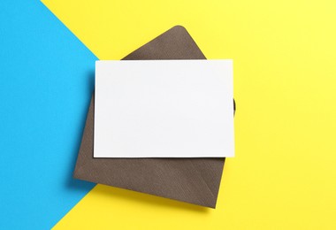 Photo of Blank invitation card and envelope on color background, top view. Space for design