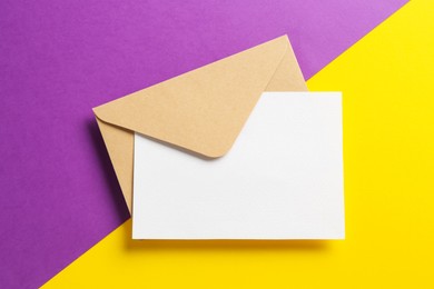 Photo of Blank invitation card and envelope on color background, top view. Space for design
