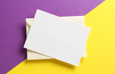 Photo of Blank invitation card and envelope on color background, top view. Space for design