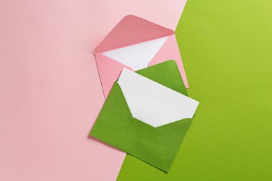 Photo of Blank invitation cards and envelopes on color background, flat lay
