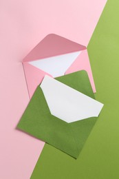 Photo of Blank invitation cards and envelopes on color background, flat lay
