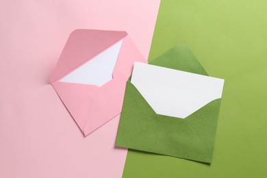 Photo of Blank invitation cards and envelopes on color background, flat lay