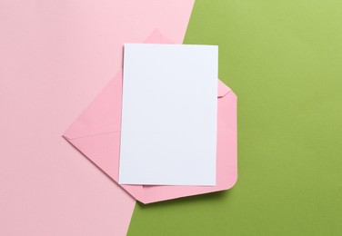 Photo of Blank invitation card and envelope on color background, top view. Space for design