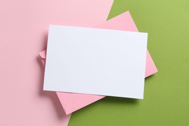 Photo of Blank invitation card and envelope on color background, top view. Space for design