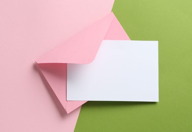 Photo of Blank invitation card and envelope on color background, top view. Space for design
