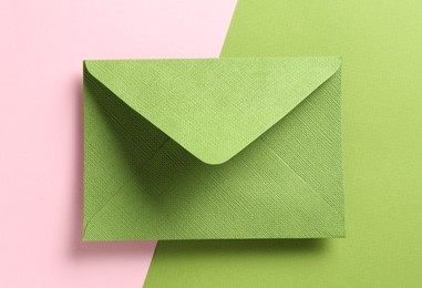 Photo of Beautiful invitation envelope on color background, top view