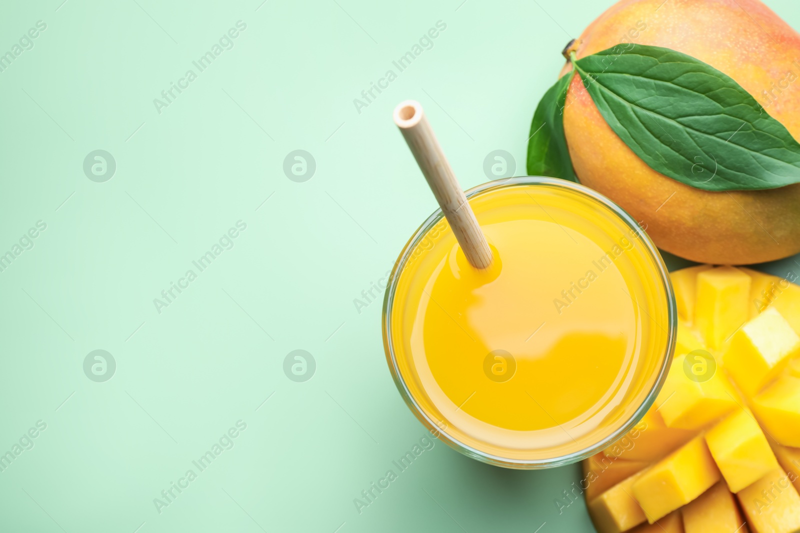 Tasty mango juice in glass and fresh fruits on green background, flat lay. Space for text Photo of Tasty mango juice in glass and fresh fruits on green background, flat lay. Space for text