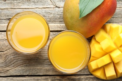 Photo of Tasty mango juice in glasses and fresh fruits on wooden table, flat lay