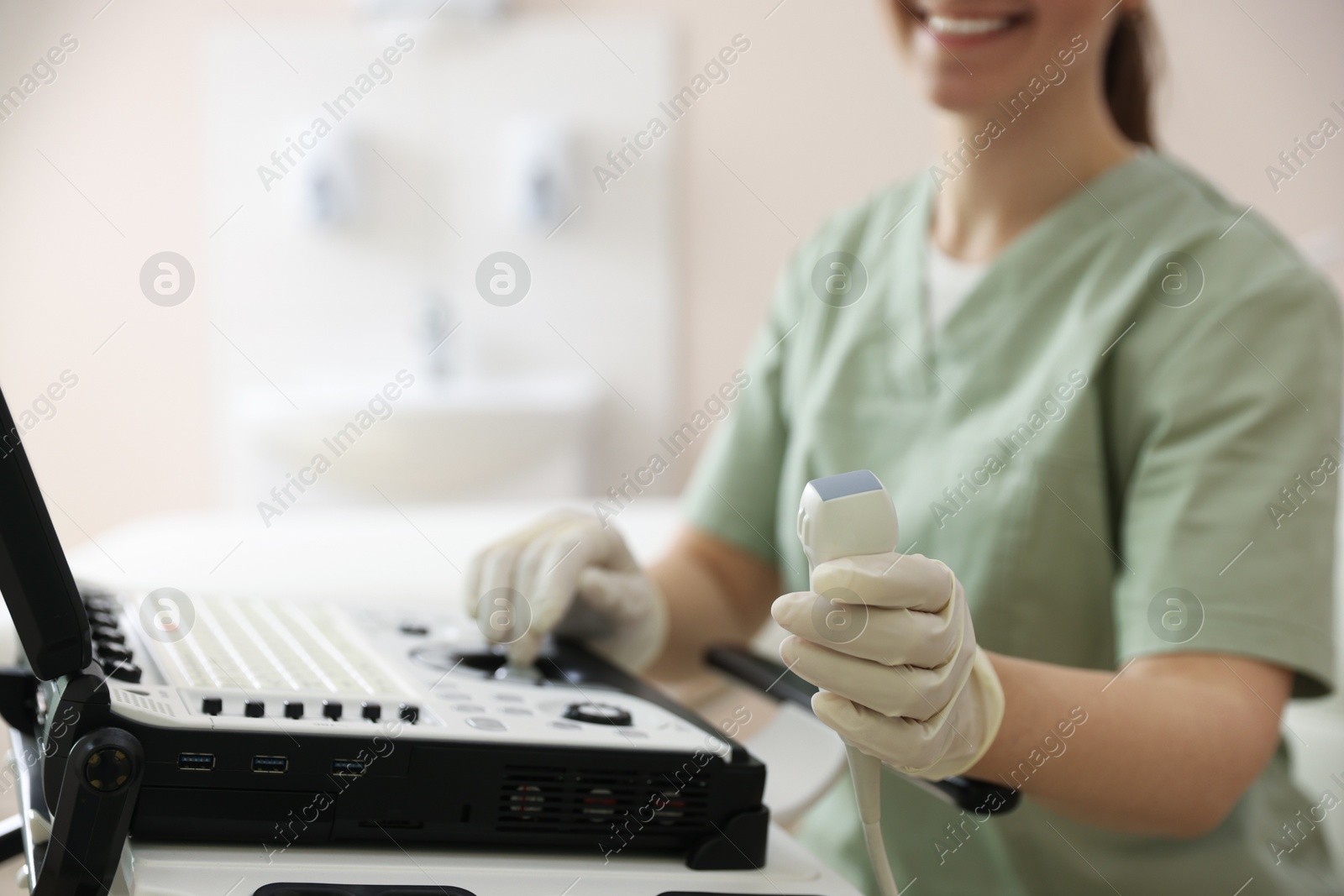 Photo of Professional sonographer with ultrasound machine in clinic, closeup