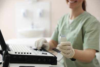 Photo of Professional sonographer with ultrasound machine in clinic, closeup
