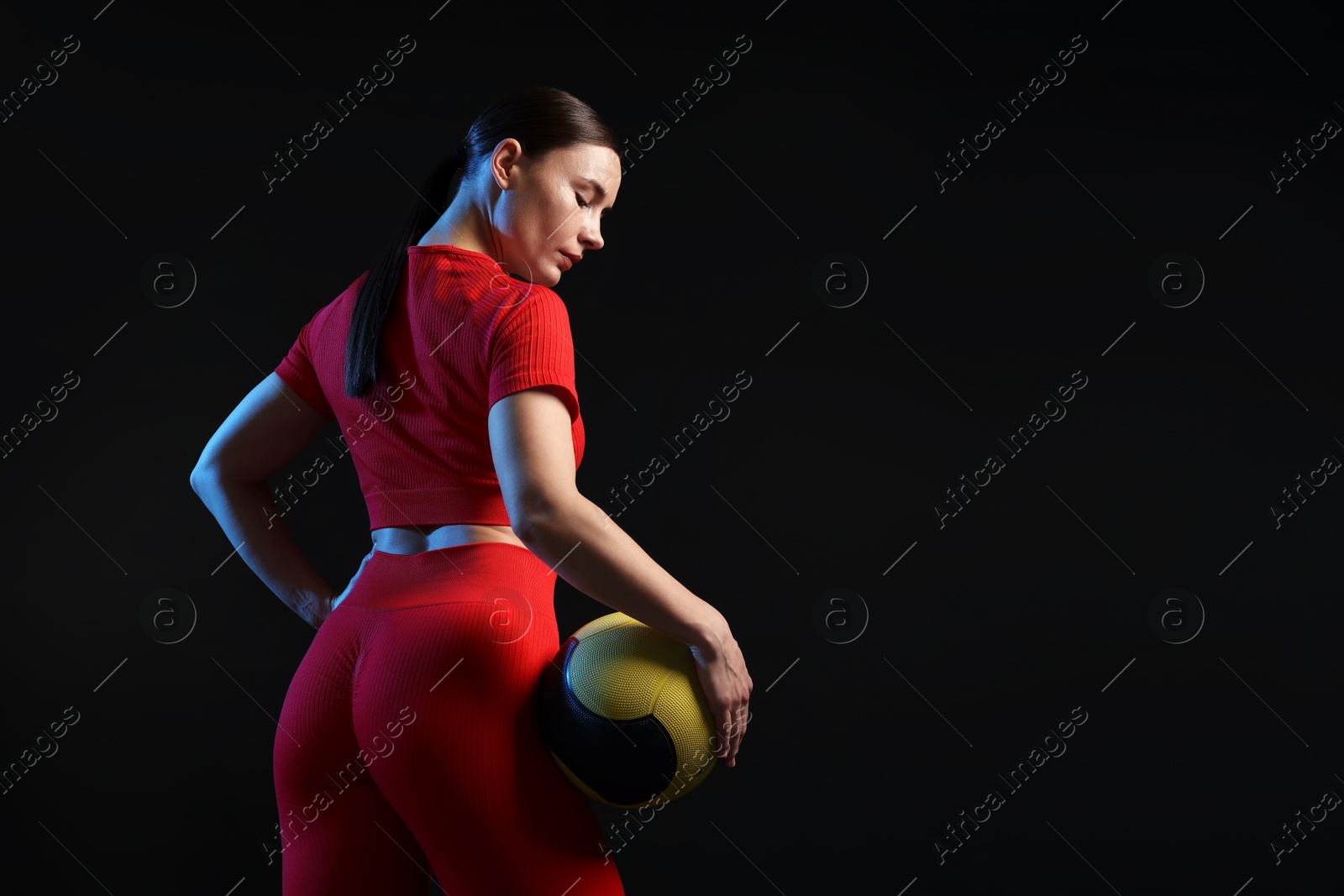 Woman with medicine ball on black background. Space for text Photo of Woman with medicine ball on black background. Space for text