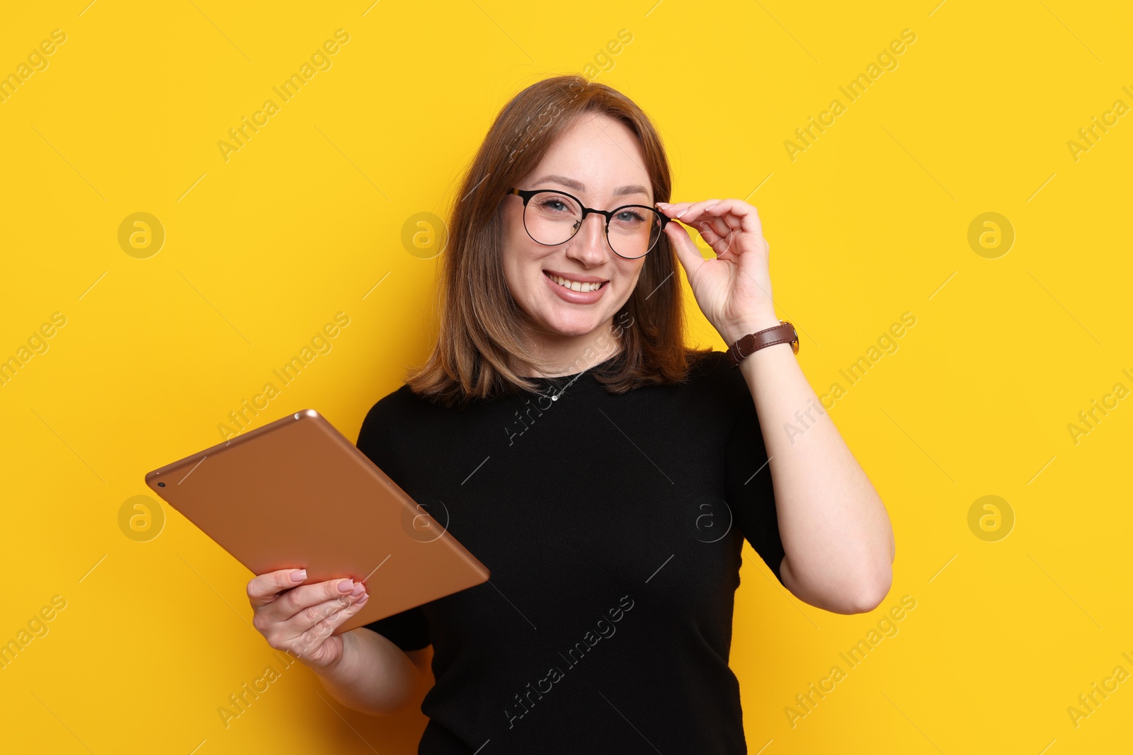 Woman with modern tablet on orange background Photo of Woman with modern tablet on orange background
