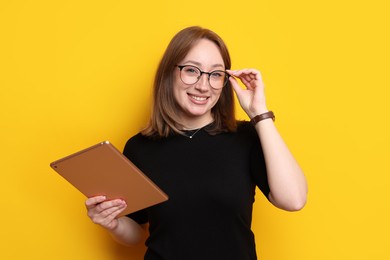 Photo of Woman with modern tablet on orange background