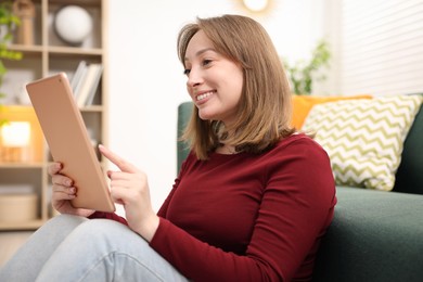 Photo of Woman with modern tablet on floor at home