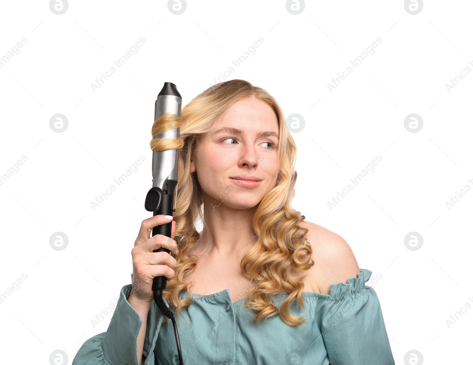 Photo of Woman curling her hair on white background