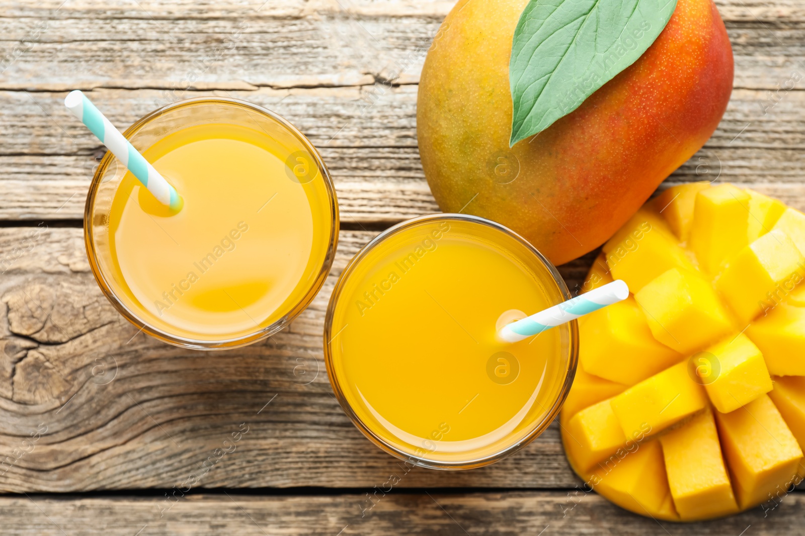 Tasty mango juice in glasses and fresh fruits on wooden table, flat lay Photo of Tasty mango juice in glasses and fresh fruits on wooden table, flat lay