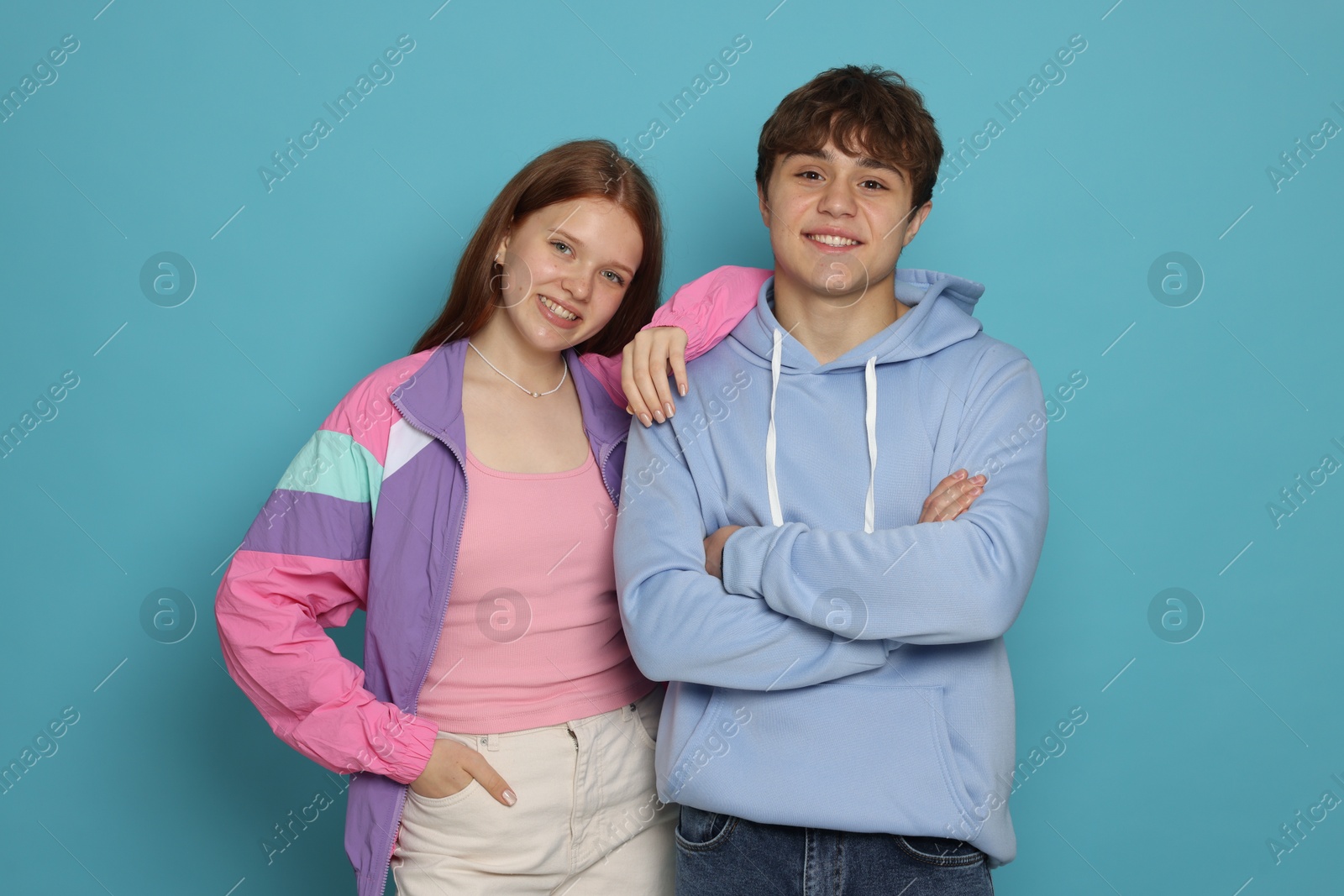 Teenage girl and boy on light blue background Photo of Teenage girl and boy on light blue background