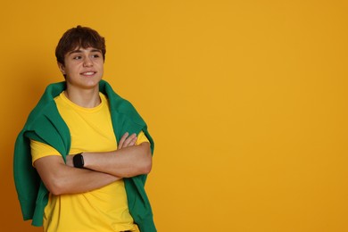 Photo of Portrait of teenage boy on yellow background. Space for text