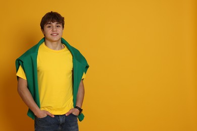 Photo of Portrait of teenage boy on yellow background. Space for text