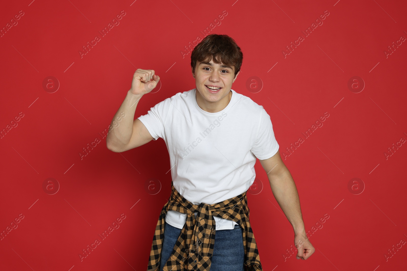 Portrait of excited teenage boy on red background Photo of Portrait of excited teenage boy on red background