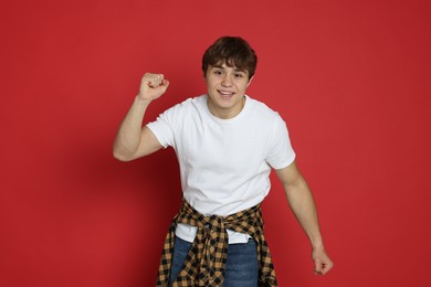 Photo of Portrait of excited teenage boy on red background