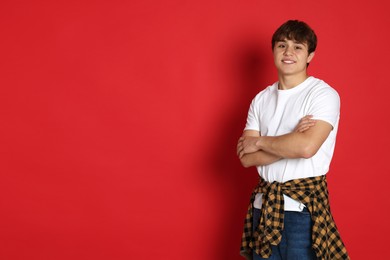 Photo of Portrait of teenage boy on red background. Space for text