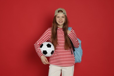 Photo of Teenage girl with soccer ball on red background