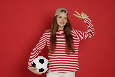 Photo of Teenage girl with soccer ball on red background