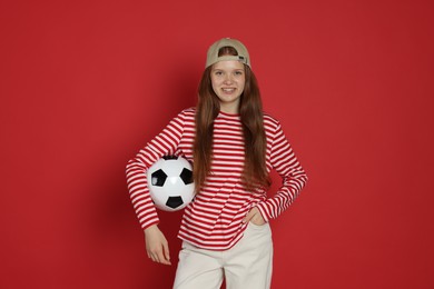 Photo of Teenage girl with soccer ball on red background
