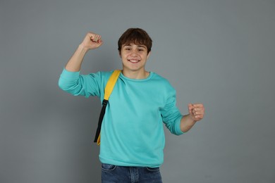 Photo of Portrait of excited teenage boy on grey background