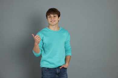 Photo of Portrait of teenage boy on grey background
