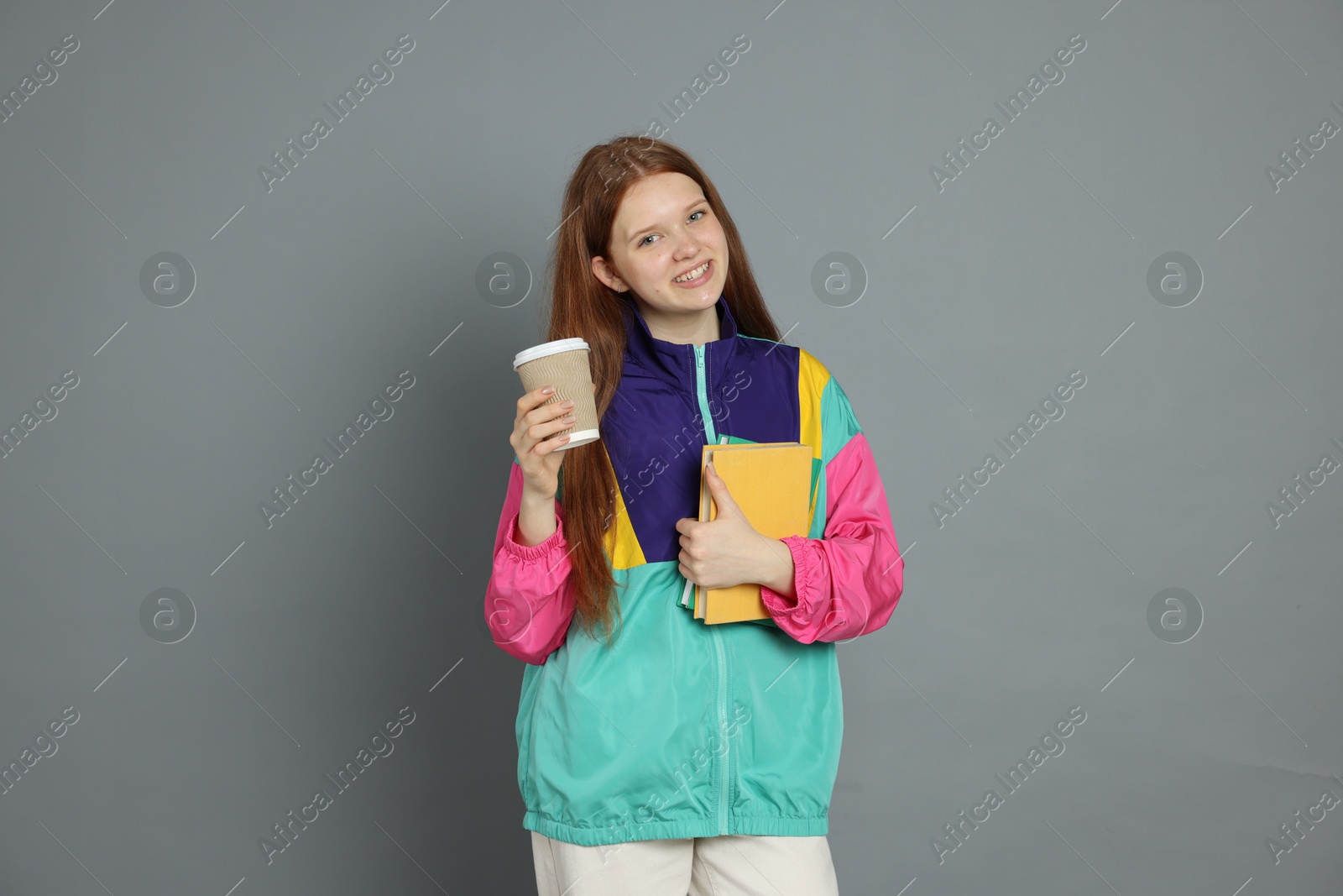 Photo of Teenage girl with drink on grey background