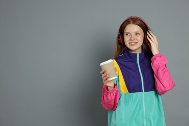 Photo of Teenage girl with drink on grey background. Space for text