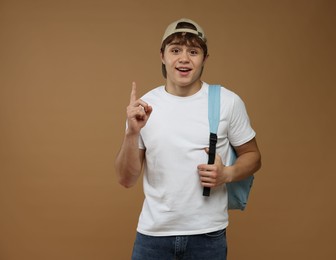 Photo of Portrait of excited teenage boy on brown background