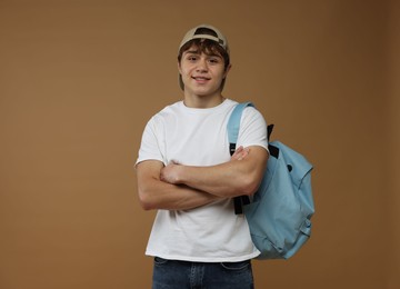 Photo of Teenage boy with backpack on brown background
