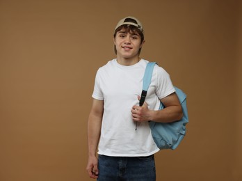 Photo of Teenage boy with backpack on brown background