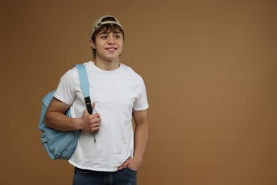 Photo of Teenage boy with backpack on brown background. Space for text