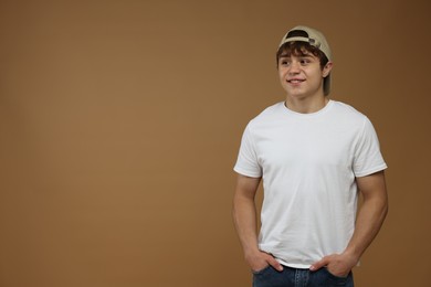 Photo of Portrait of teenage boy on brown background. Space for text