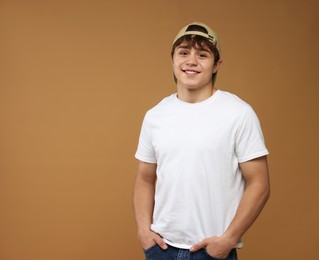 Photo of Portrait of teenage boy on brown background