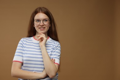 Photo of Portrait of teenage girl on brown background. Space for text