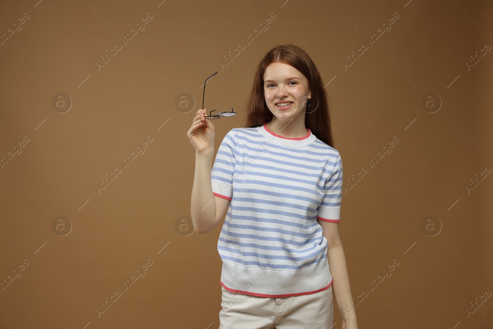 Portrait of teenage girl on brown background Photo of Portrait of teenage girl on brown background