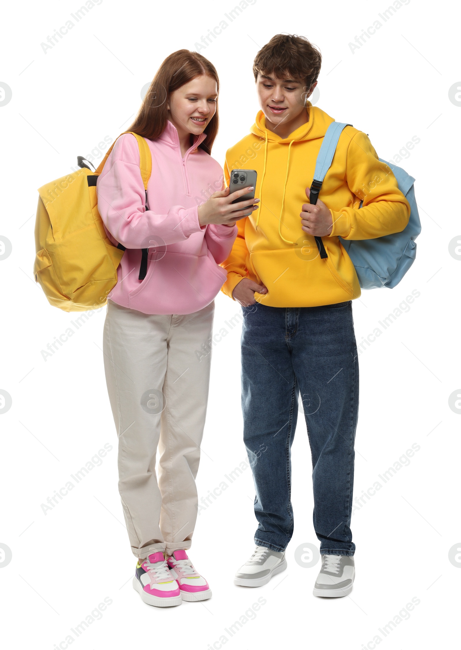 Teenage girl showing her friend something on smartphone against white background Photo of Teenage girl showing her friend something on smartphone against white background