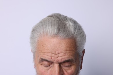 Photo of Man with silver hair on light background, closeup