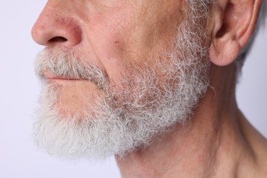Photo of Man with silver beard on light background, closeup